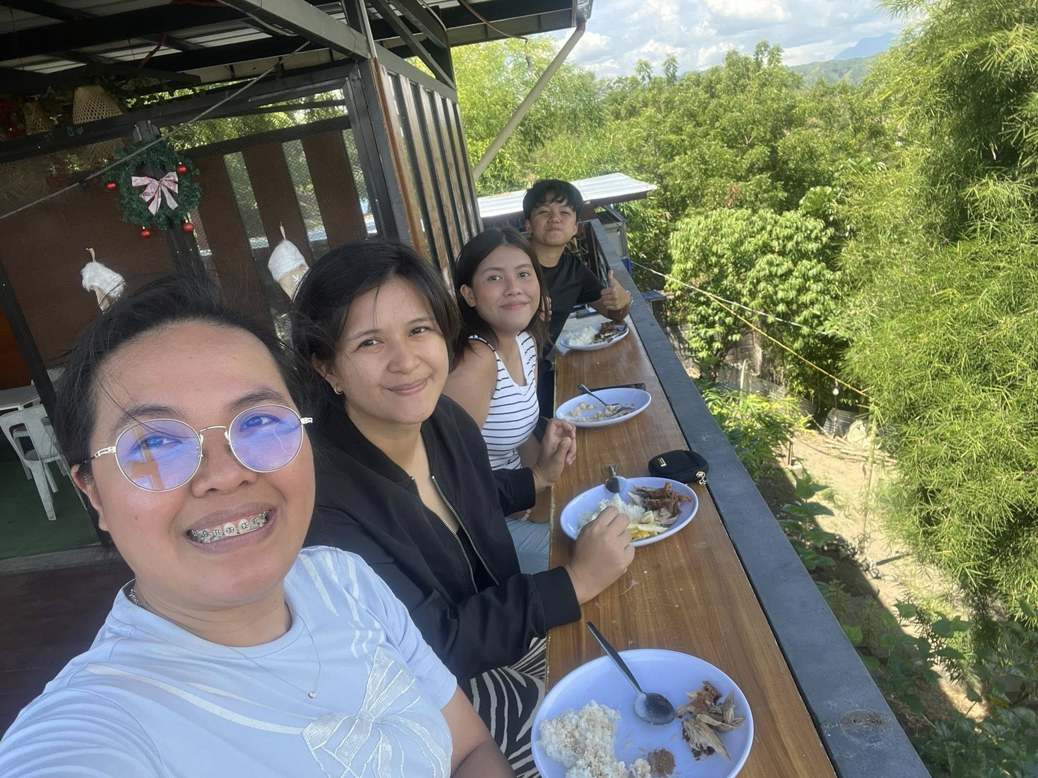 Friends dining at the balcony counter above the trees