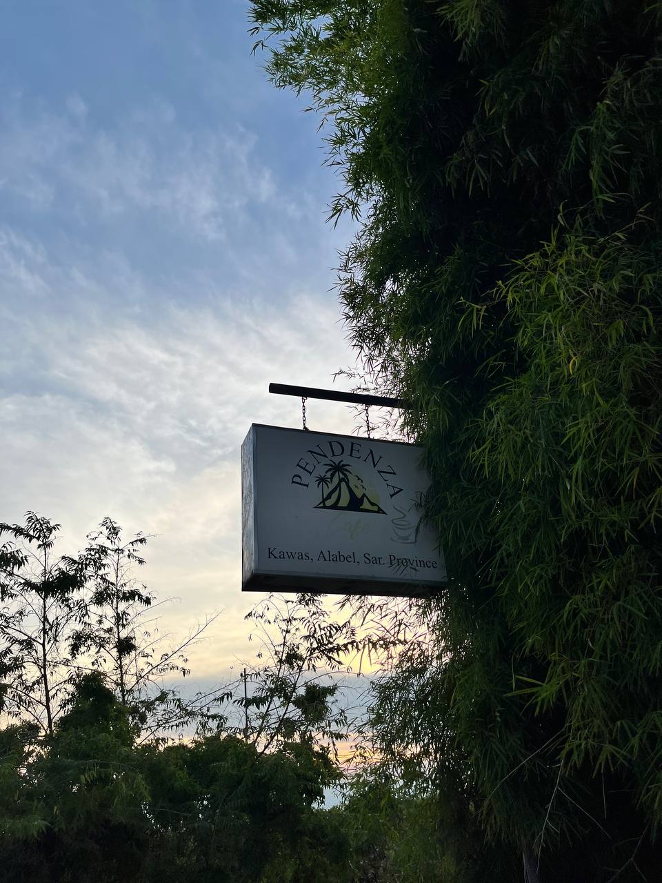 Pendenza Cafe sign against the evening sky